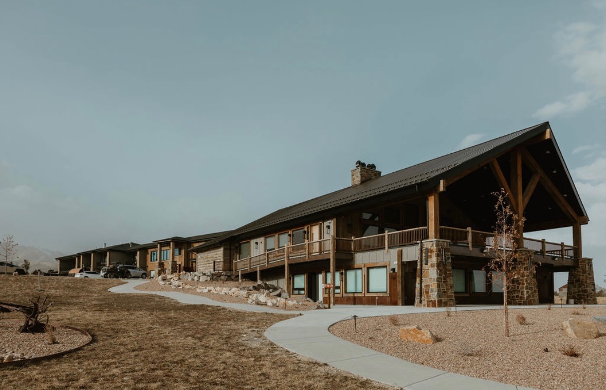 Elk Ridge Lodge at Royal Creek Ranches set against clear blue skies and scenic mountain views — ideal for large retreats and events.
