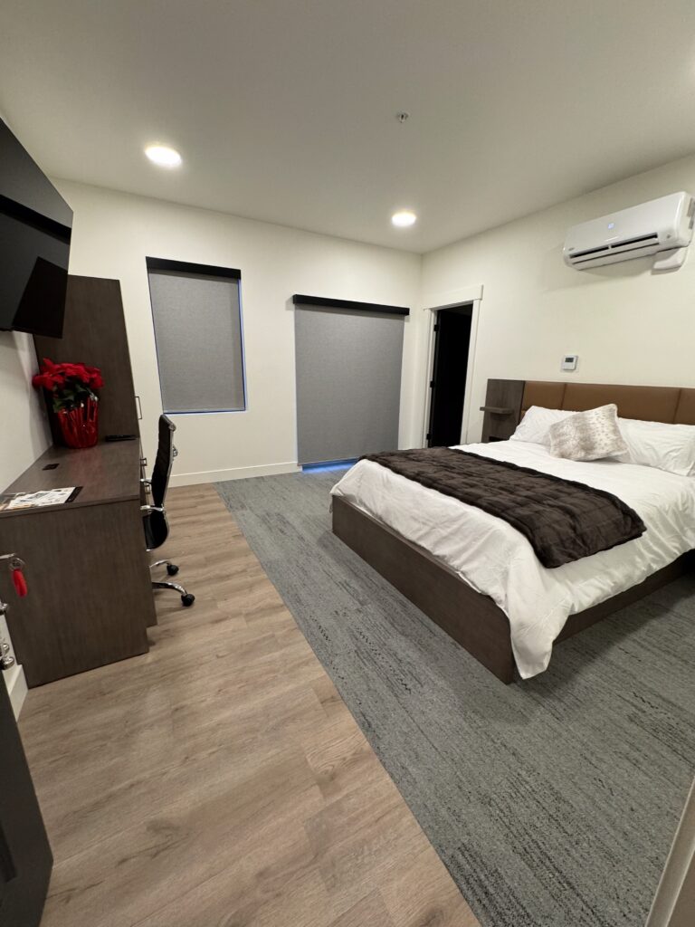 Interior view of the Oakley bedroom at Royal Creek Ranches, featuring a cozy bed, mounted TV, and comfortable furnishings for family reunion guests.