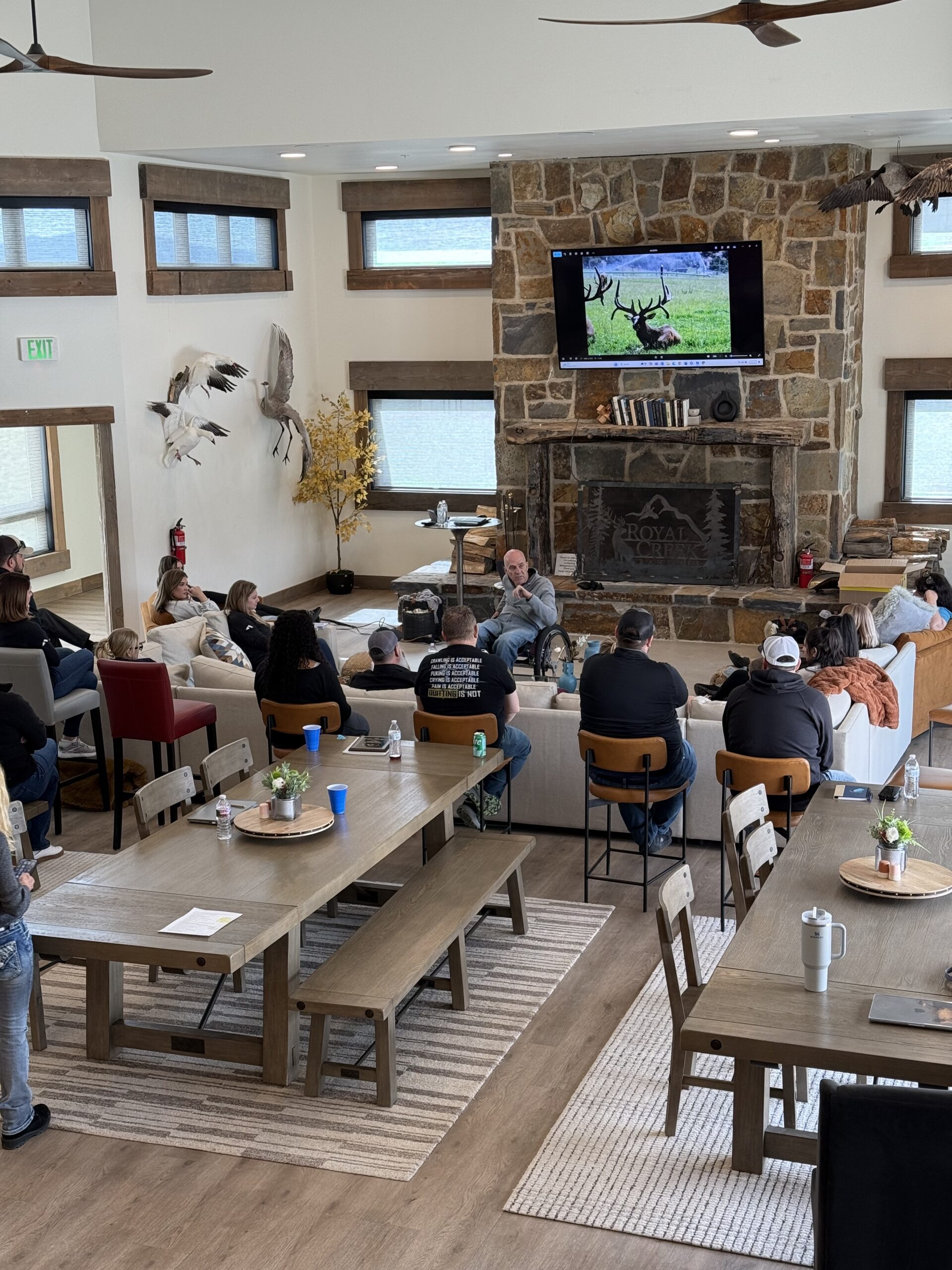 Team members relaxing and connecting in the spacious lodge living room at Royal Creek Ranches during a corporate retreat.