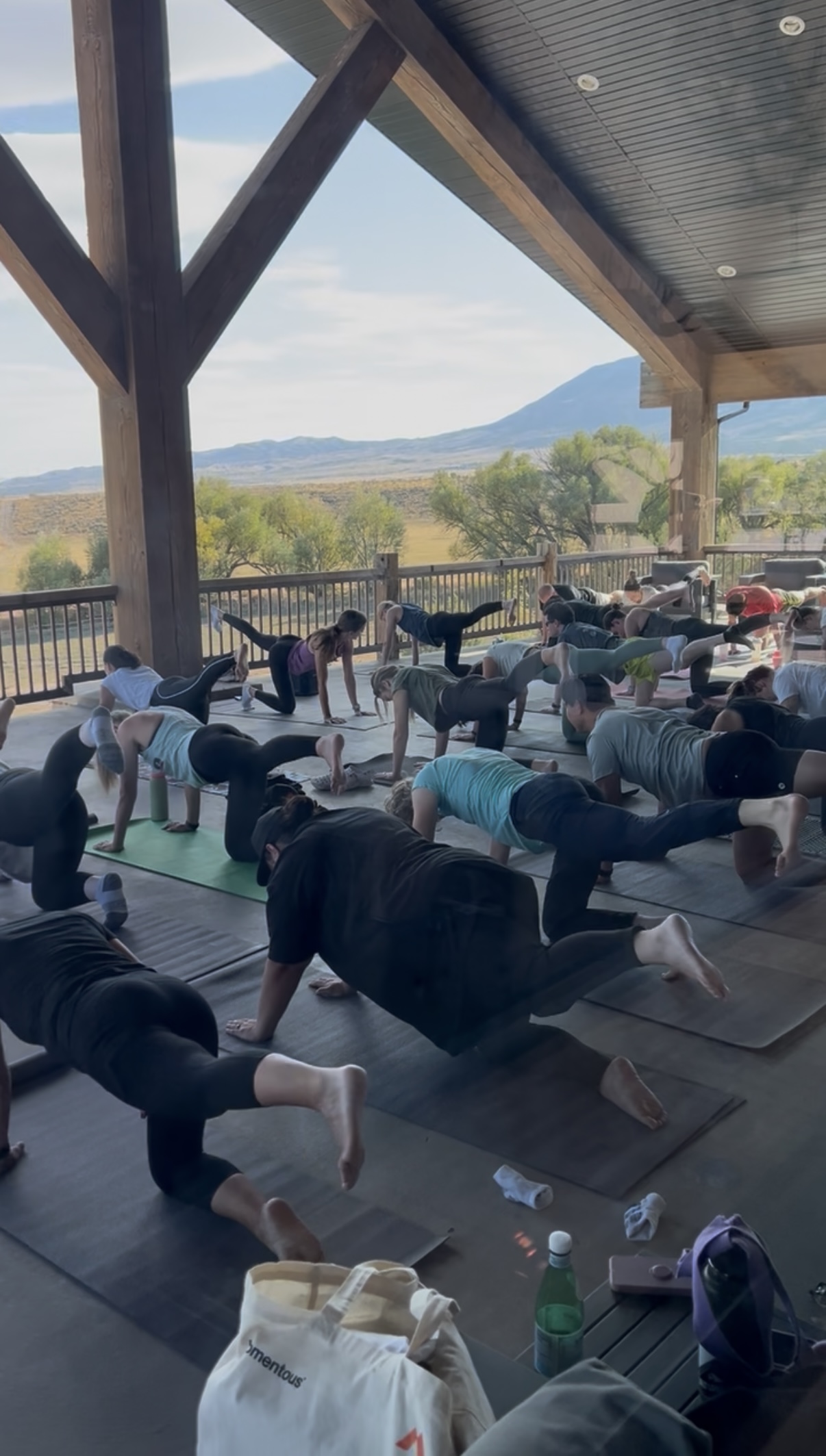 Corporate retreat guests practicing group yoga on the outdoor deck overlooking the Utah mountains at Royal Creek Ranches.